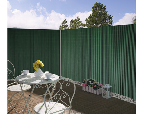 Scen med insynsskydd, bord och stolar på en terrass