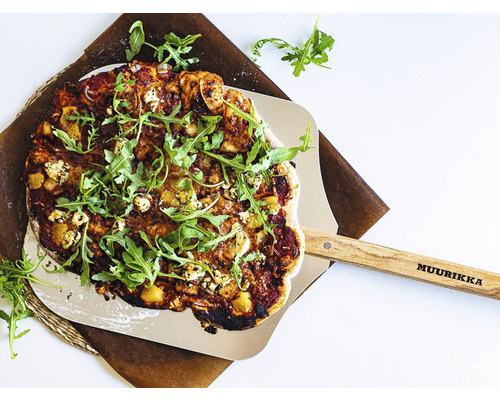 En pizza på en pizzaspade med trähandtag och Muurikka logotyp.