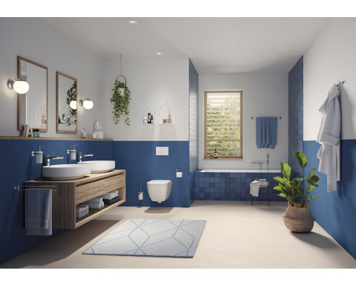 Modernt badrum med handfat, speglar, toalett och badkar i blått och vitt