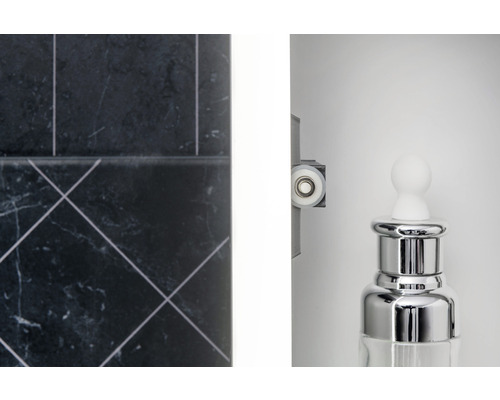 Närbild av ett badrum med kakel, duschkabinroll och en dispenser