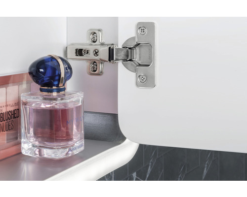 Gångjärn på ett vitt skåp med kosmetiska produkter