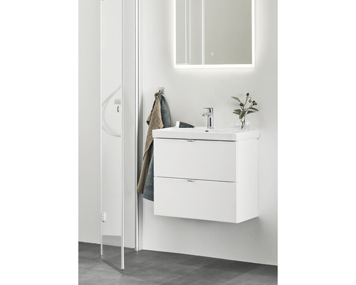 Modernt badrum med tvättställsskåp, spegel med belysning och duschkabin