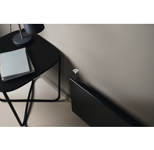 Bild av ett värmeelement, ett sidobord, en lampa och böcker