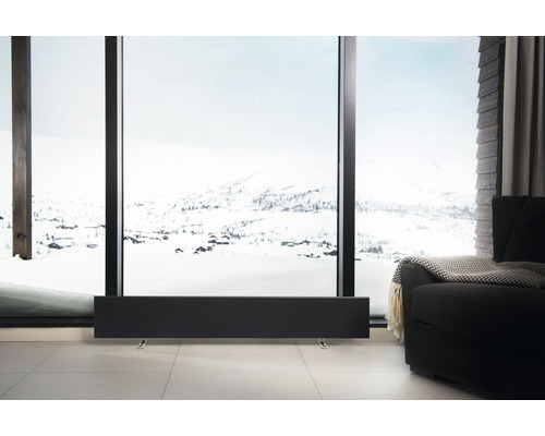 Miljö med modern radiator framför ett fönster med ett snöigt landskap