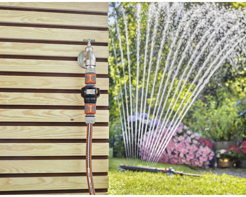 Trädgårdsscen med kran, Gardena vattenmätare och grässpridare