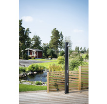 Utedusch på en träterrass med trädgårdsdamm och litet hus i bakgrunden