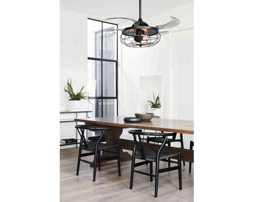 Matsal med takfläkt i burdesign och träbord med stolar.