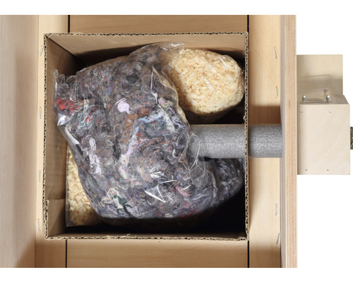 Förpackningsmaterial i en kartong, bestående av träull, textilfibrer i en plastpåse och ett grått skumrör