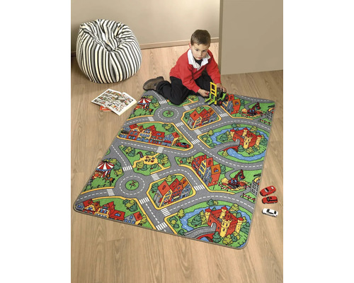 Lekmatta med gatumönster och barn som leker med leksaksbilar och en leksaksgrävmaskin