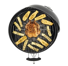 Rund grill med kyckling och zucchini på träkol