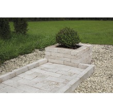 Trädgårdsscen med planteringslåda och gångväg av travertin