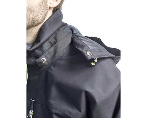 Detaljvy av en svart outdoorjacka med huva och tryckknappar