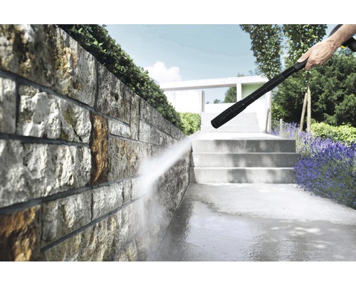 Högtryckstvätt används för att rengöra en stenmur och en gångväg