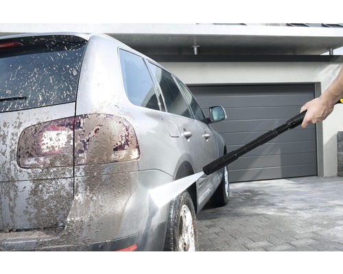 Rengöring av en smutsig bil med en högtryckstvätt.