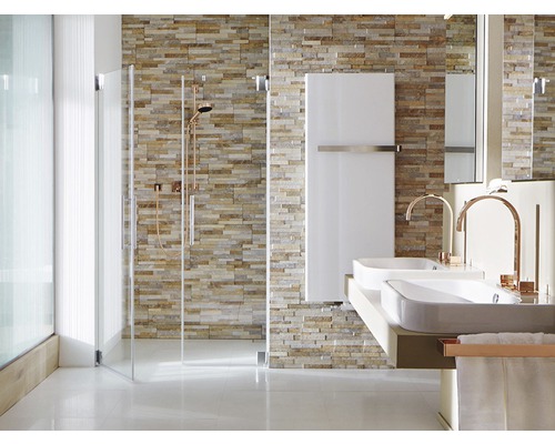 Badrum med dusch, handfat och radiator framför stenmur