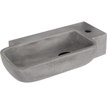 Grått tvättställ i sten med avlopp