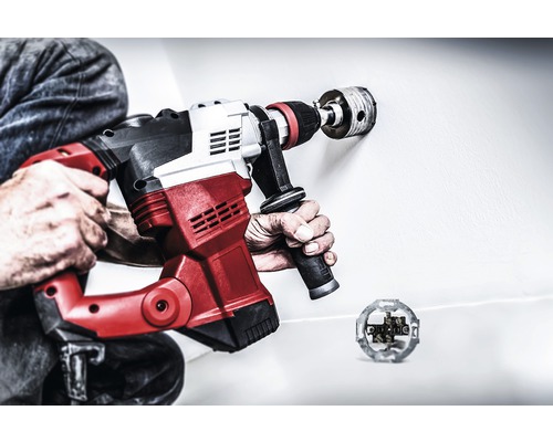 Man borrar ett hål i en vägg med en kärnborrmaskin för ett eluttag