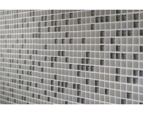 Närbild av en vägg med små, fyrkantiga mosaikplattor.