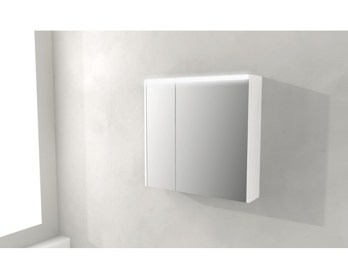 Spegelskåp med belysning monterat på en vägg