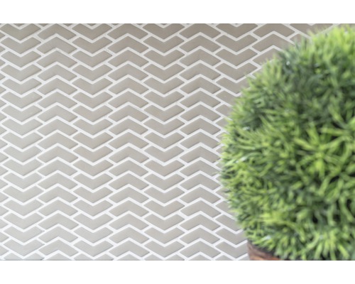 Kakelvägg med fiskbensmönster och växt