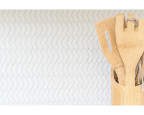 Köksredskap av bambu i behållare mot vit bakgrund