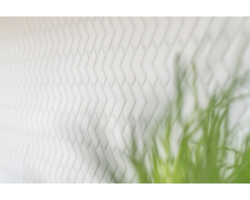 Vit tegelvägg med fiskbensmönster