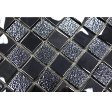 Närbild av svarta mosaikplattor med en blank och texturerad yta
