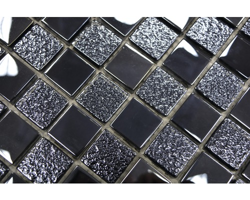 Närbild av svarta mosaikplattor med en blank och texturerad yta