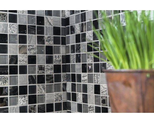 Väggkakel med mosaikmönster i svart, grått och vitt.