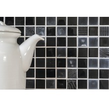 Dekorativ mosaikplatta i kvadratiskt format framför en tekanna