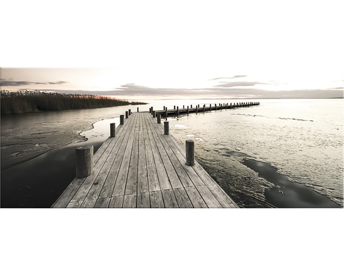 Träbrygga vid sjön med is på vintern