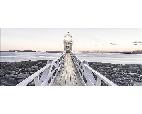 Foto av en fyr i änden av en brygga av trä