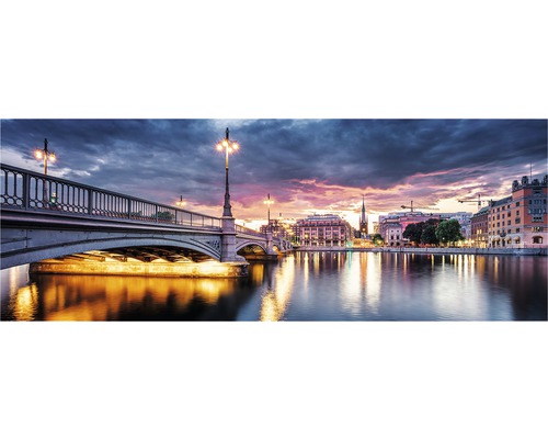 Panoramavy över en kvällsstadsbild med bro och upplysta byggnader