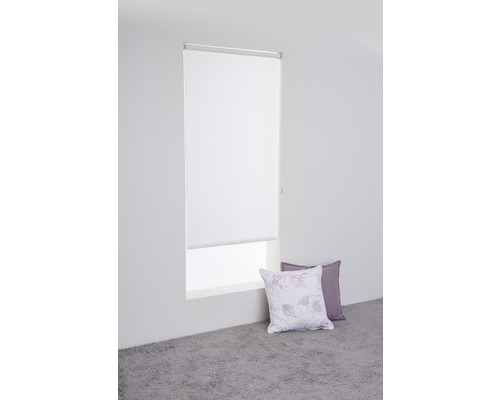 Vit rullgardin vid fönstret med kuddar på golvet