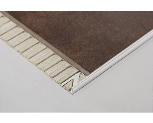 Kakelprofil av metall på en brun kakelplatta