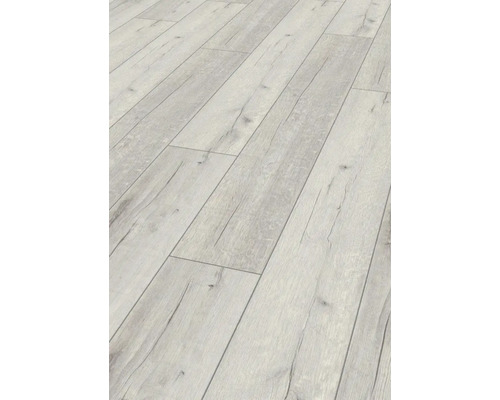 Detaljbild av ett ljust laminatgolv med träutseende.