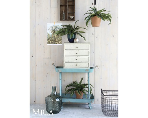 Dekorativ inredning med hyllvagn, krukväxter och byrå