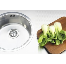 Diskho i rostfritt stål bredvid pak choi på träbräda
