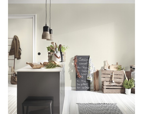 Ljust kök med köksö, griffeltavla och trälådor för förvaring.