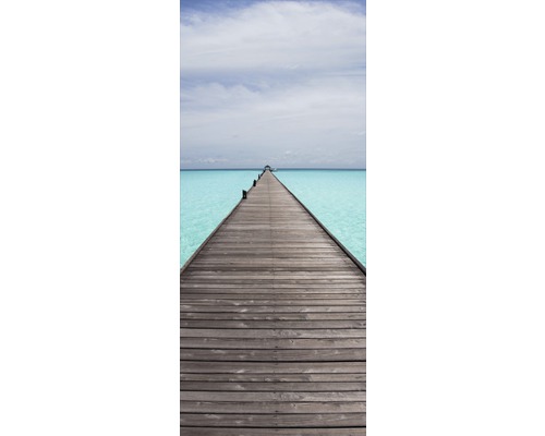 Träbrygga över turkost vatten under en ljus himmel.