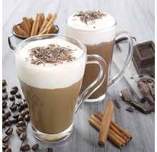 Två kaffedrycker i glas med vispgrädde och chokladflingor, kaffebönor och kanelstänger på ett bord