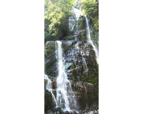 Vattenfall mellan stenar och växtlighet