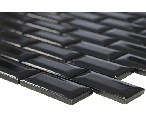 Närbild av svarta mosaikplattor i fiskbensmönster