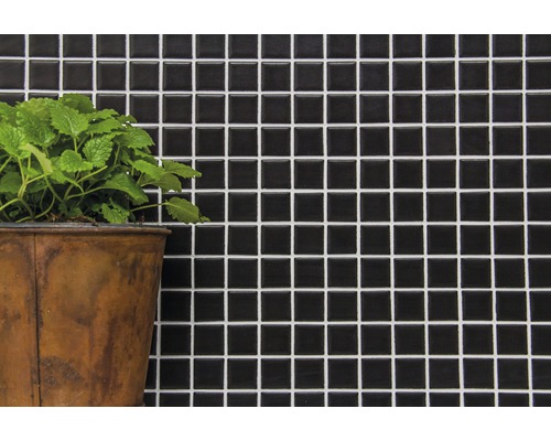 Väggplatta med mosaikmönster och växt i kruka