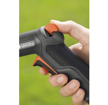 Närbild av en hand som använder en trädgårdsslang med Gardena logotyp