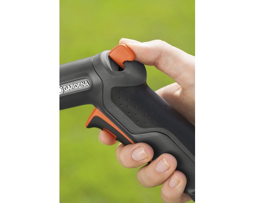 Närbild av en hand som använder en trädgårdsslang med Gardena logotyp