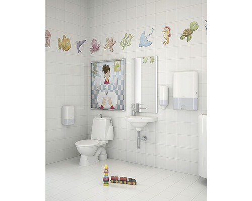 Ljust badrum med toalett, handfat, spegel, tvåldispenser, pappershandduksautomat och dekoration med havsmotiv.