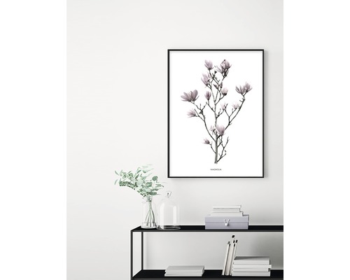 Dekorativt konsttryck med magnoliablommor i ram på en vägg