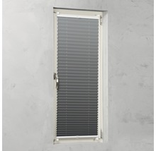 Grå plisségardin på ett fönster för ljusreglering