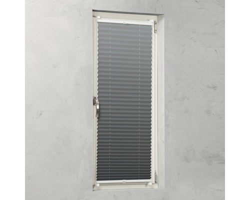 Grå plisségardin på ett fönster för ljusreglering